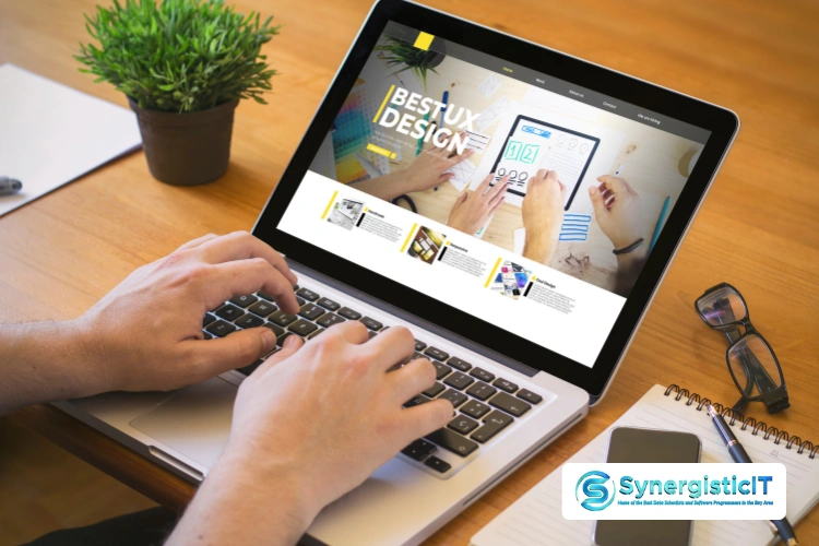 Laptop displaying SynergisticIT website and software development resources for JUnit interview preparation.