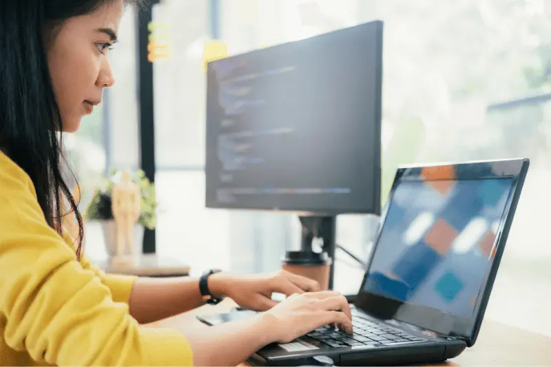 Woman coding on laptop, Java training program and software development skills.