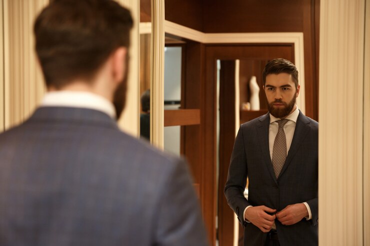Man in suit reflecting on professional attire for job interview preparation.