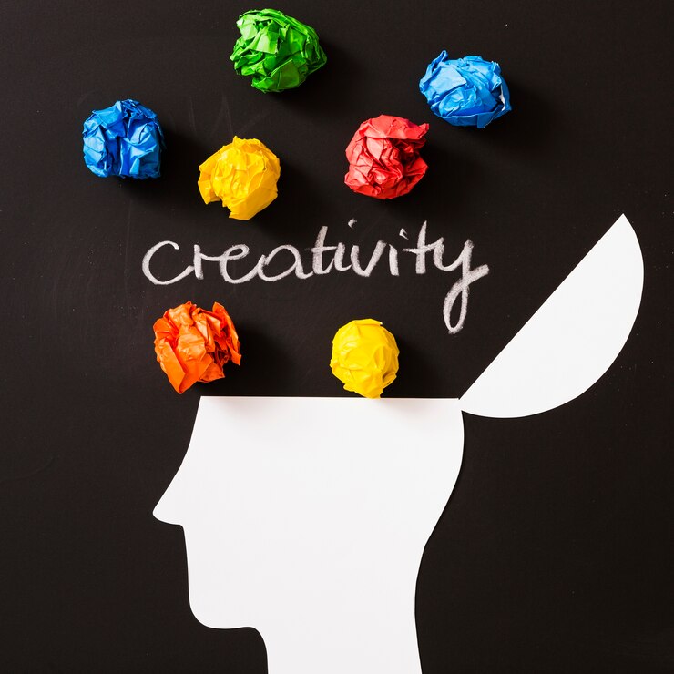Colorful crumpled paper and a brain outline representing creativity and growth mindset for tech professionals.